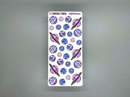 Twinkling planets color sticker sheet on gray background.