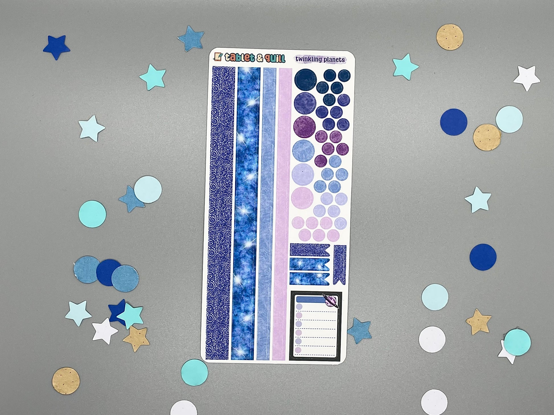 Sticker sheet with matching design as our planet themed stickers on a gray background with decorative stars and circles.
