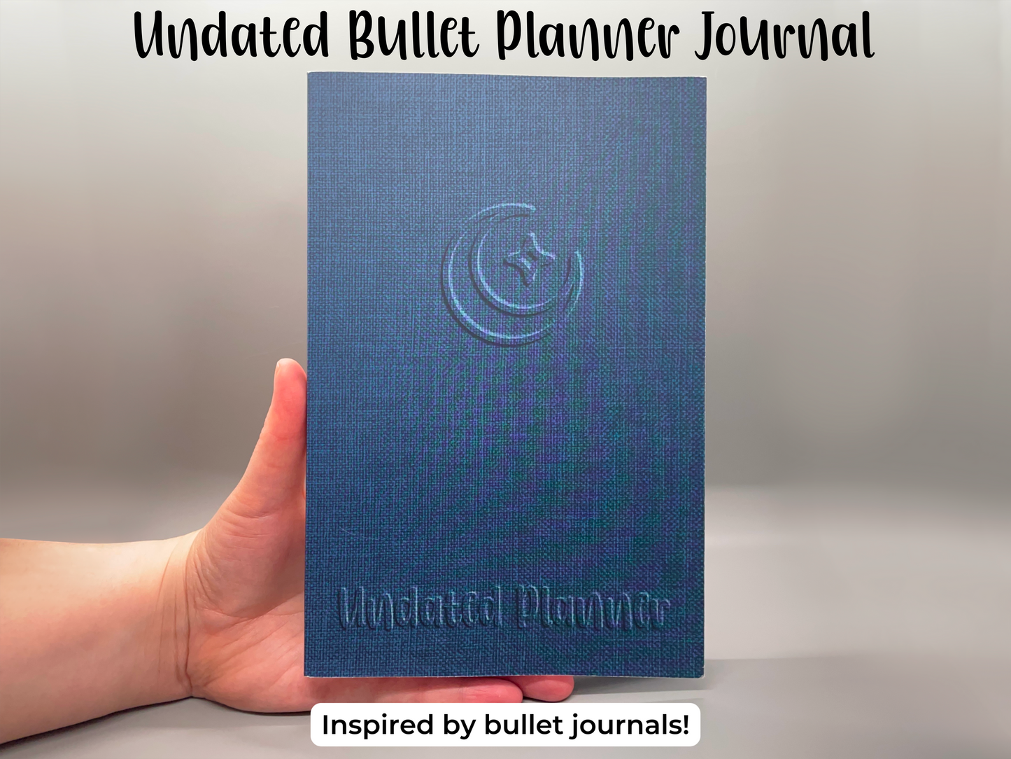 Undated bullet planner journal inspired by bullet journals. One undated planner. Blue faux-linen cover with embossed style crescent moon and sparkle design. The bottom of the planner says Undated Planner in same embossed-style.