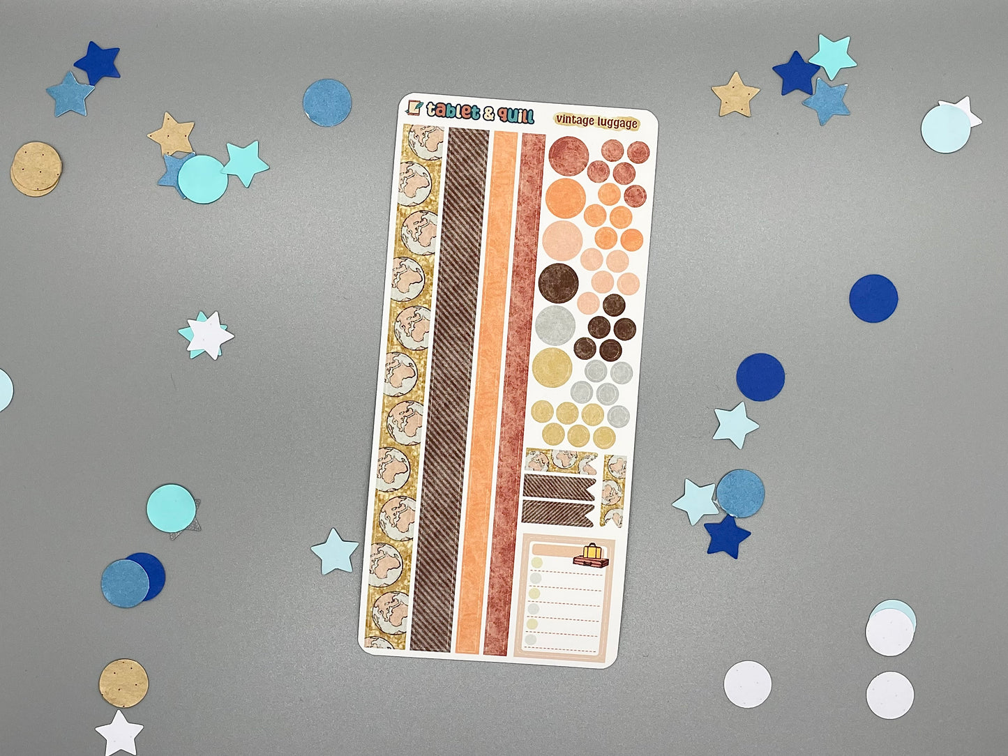 Sticker sheet with matching design as our luggage themed stickers on a gray background with decorative stars and circles.