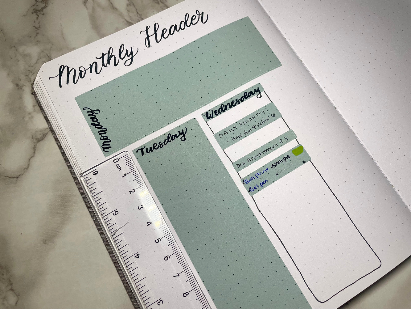 Planner stickers with days of the week labels on a marble surface